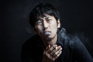 煙を吐く男性